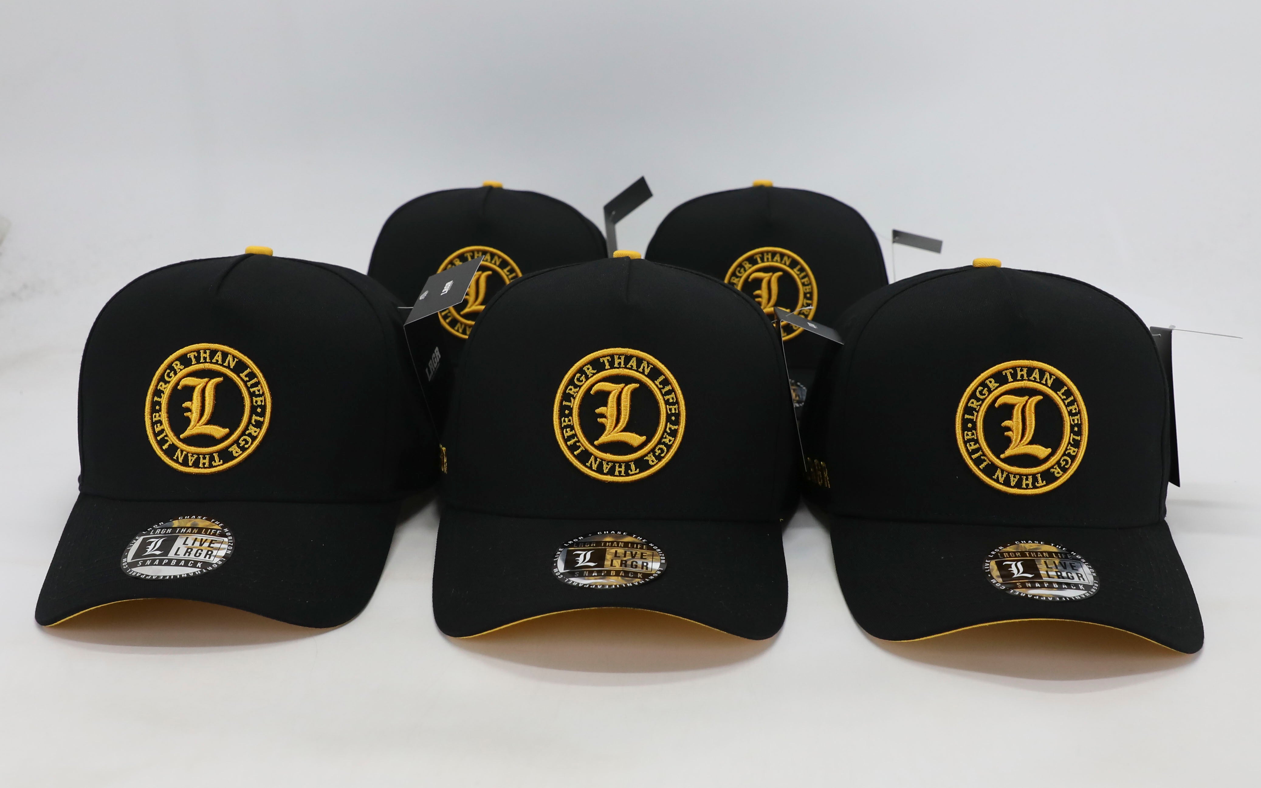 Black caps with yellow logos arranged on a white background