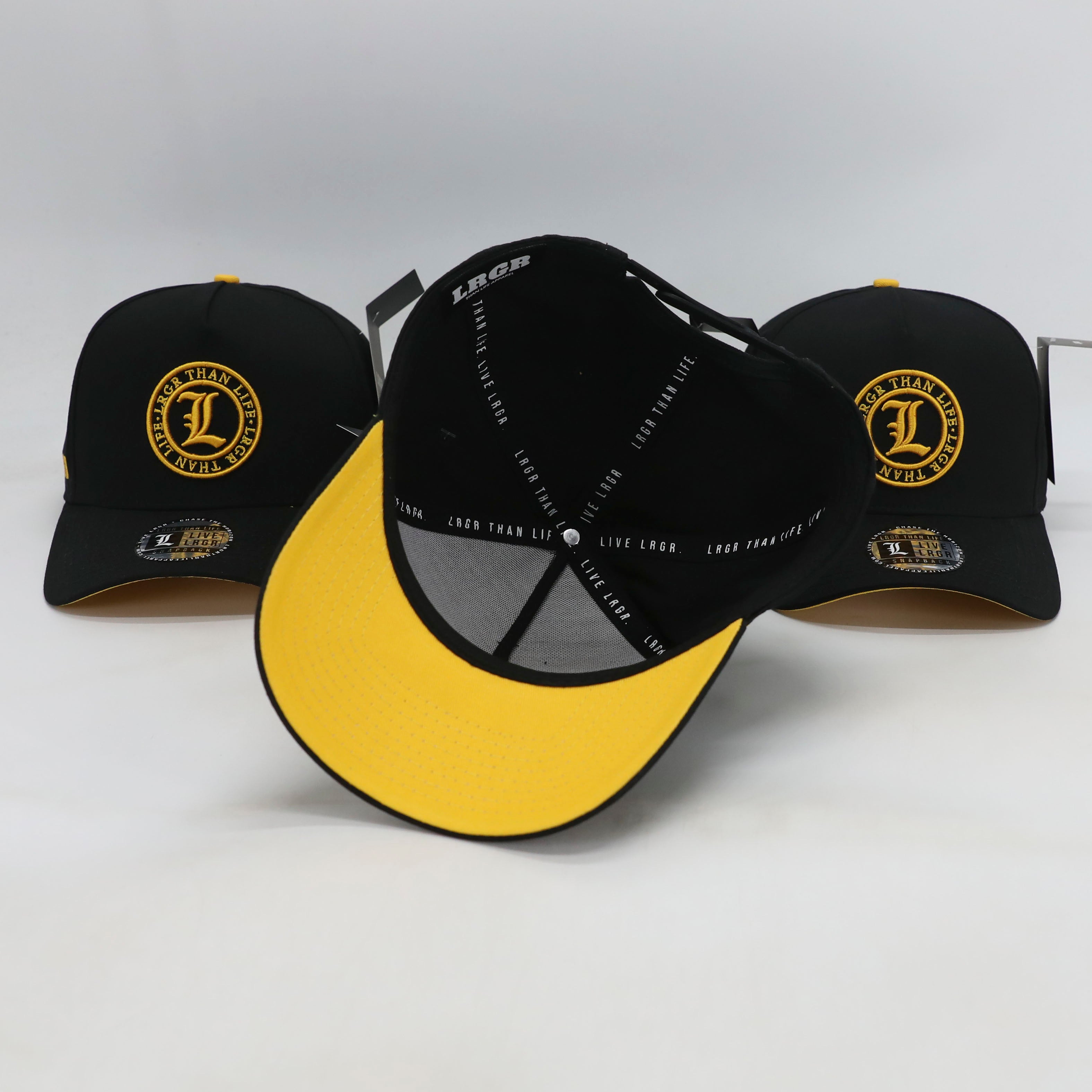 Black and yellow baseball caps with visible branding on a white background