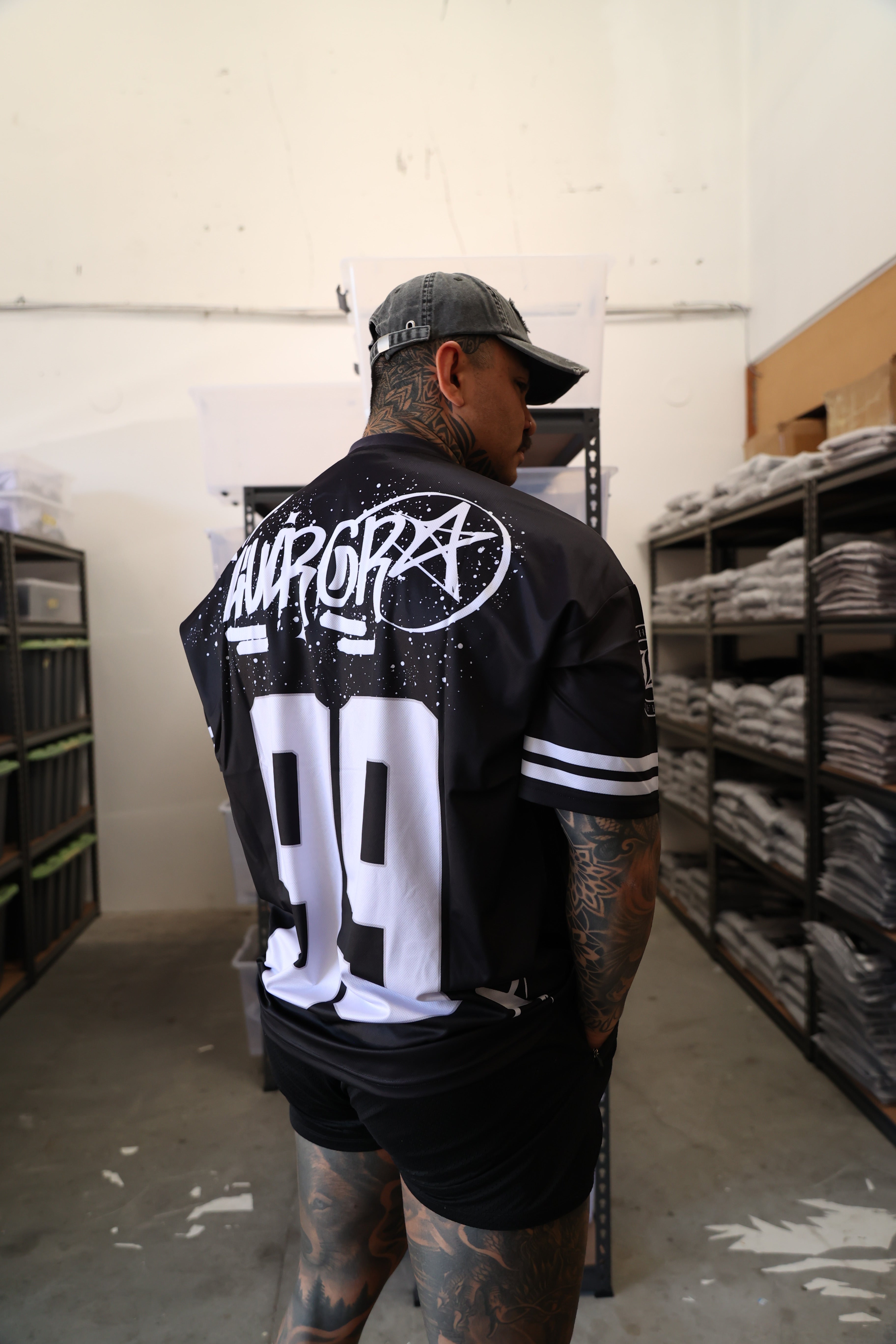 Person wearing a black and white outfit with visible branding in an indoor setting.