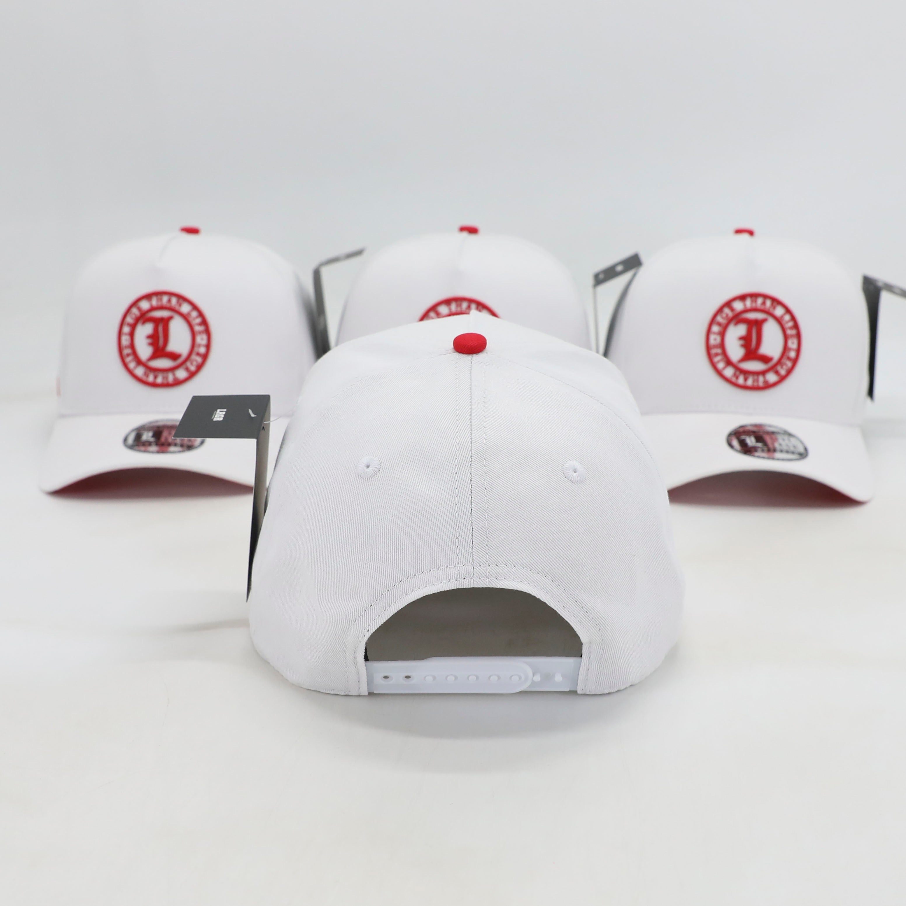 White baseball caps with red logos on a light gray background