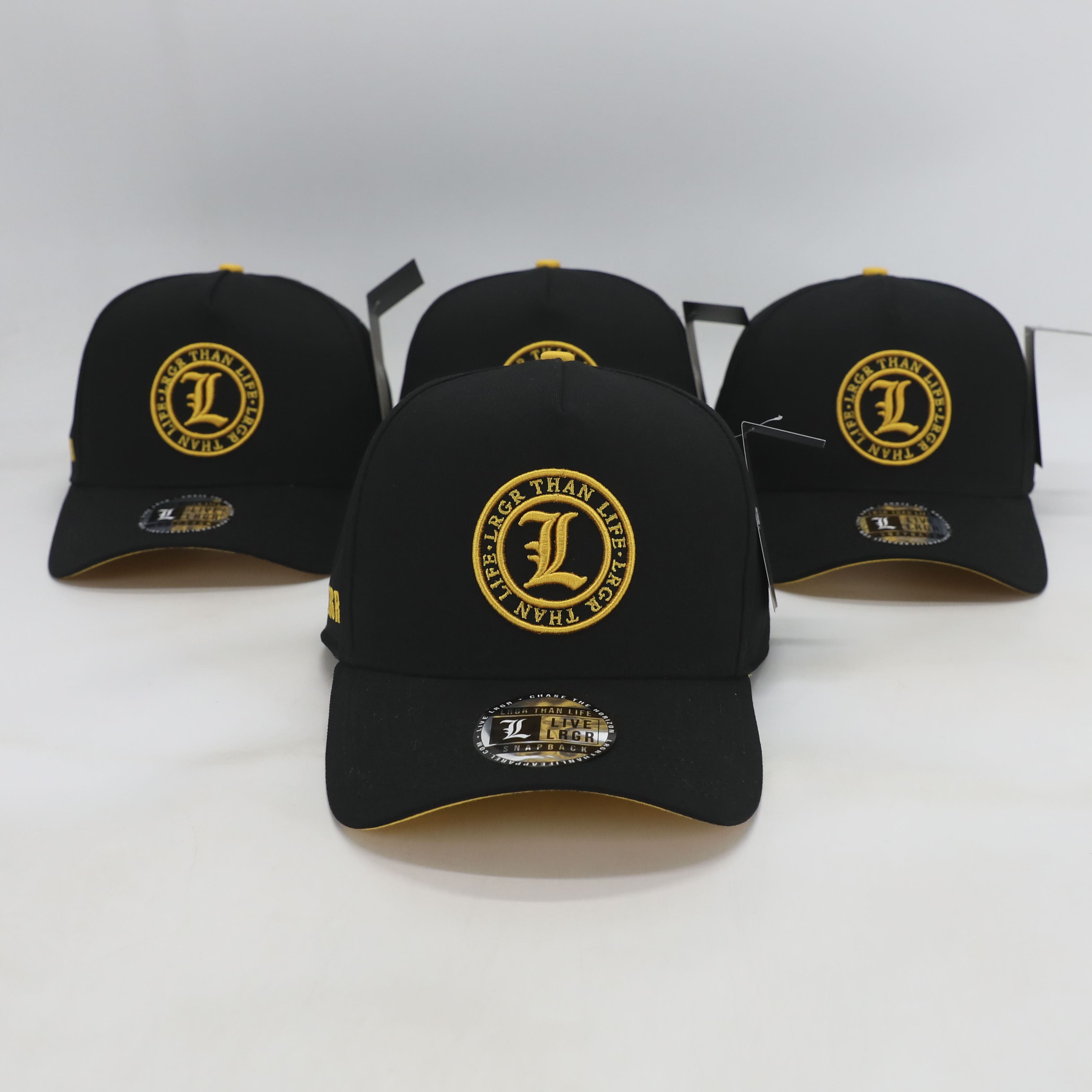 Black baseball caps with yellow logos on a white background