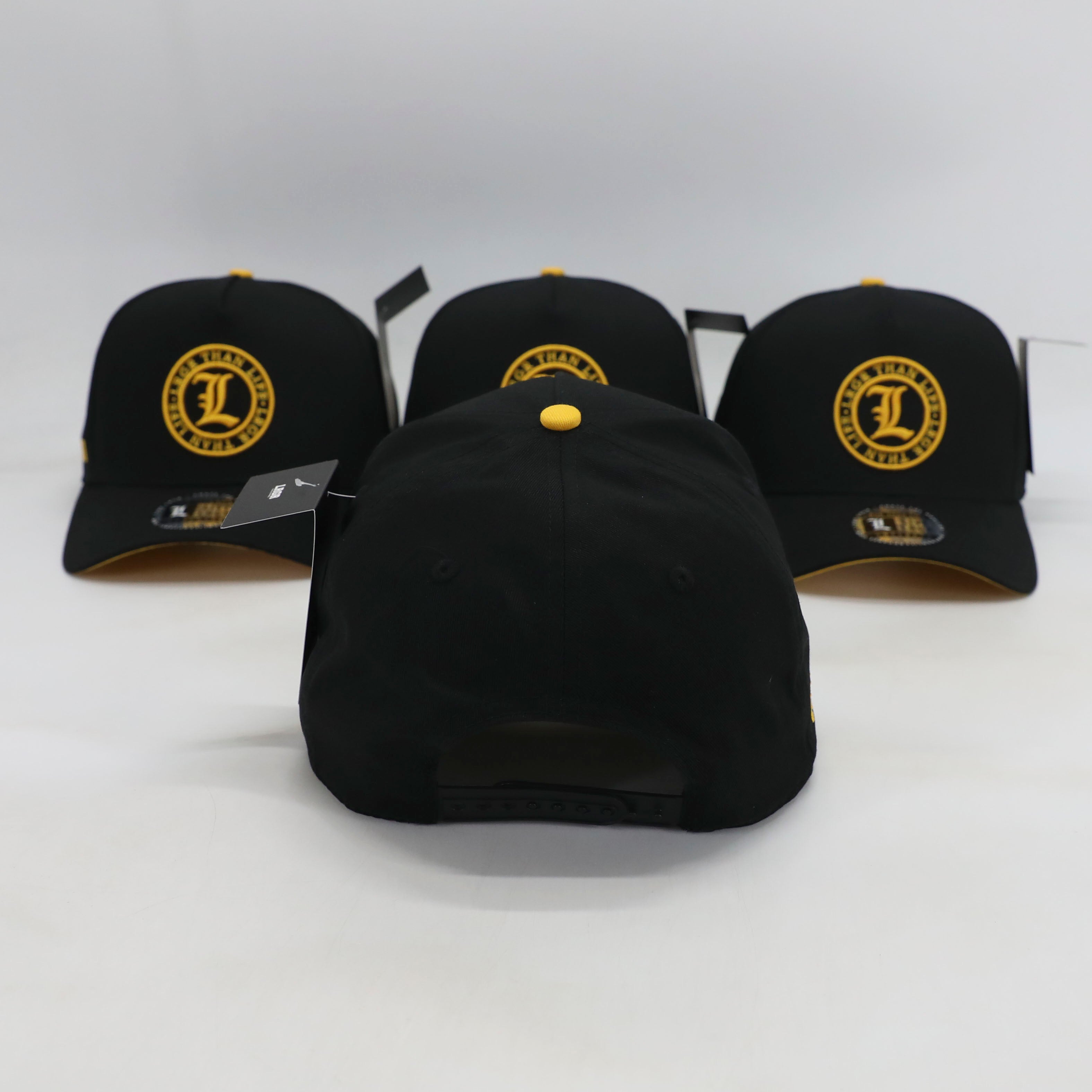Three black baseball caps with yellow logos on a white background