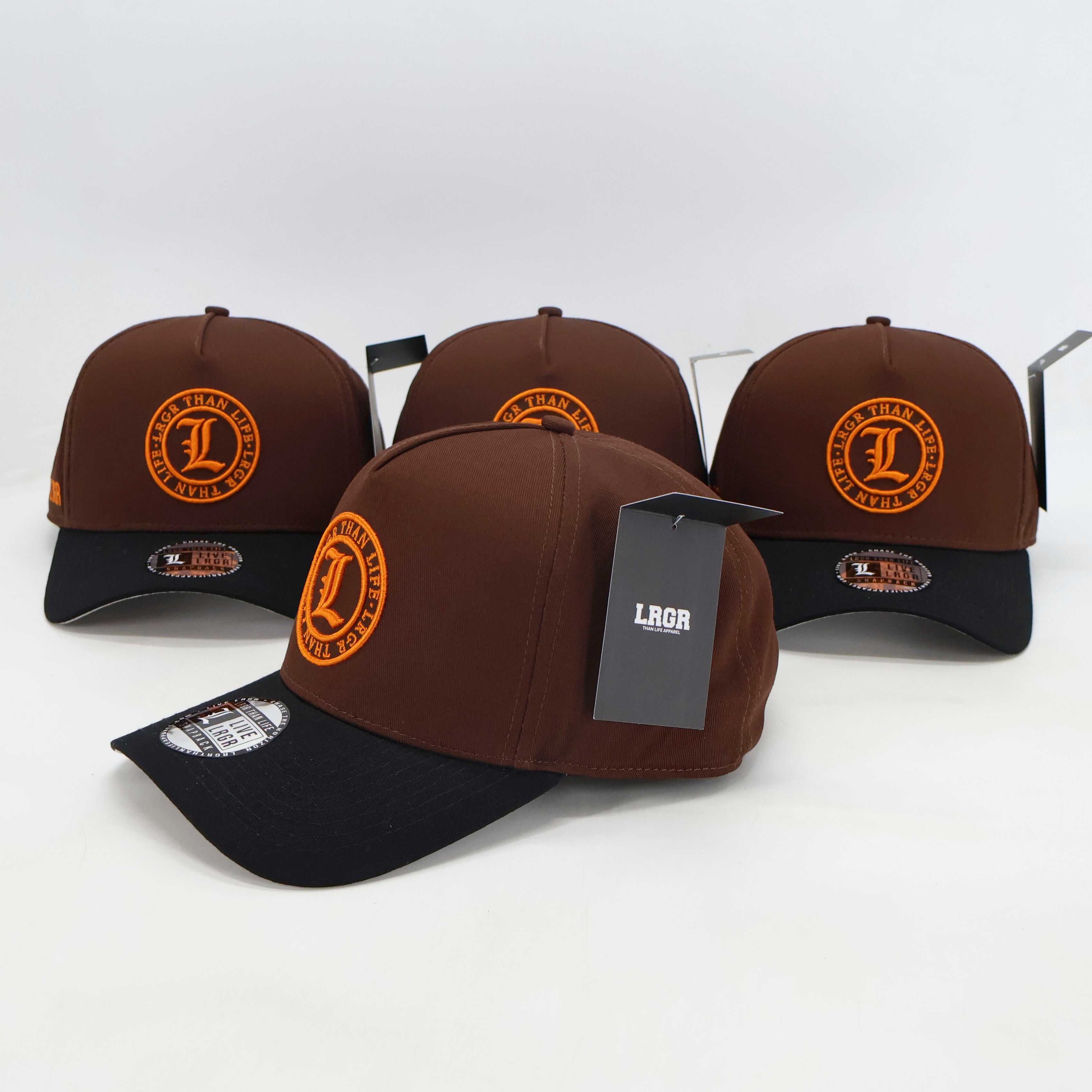 Four brown and black baseball caps with orange logos on a white background