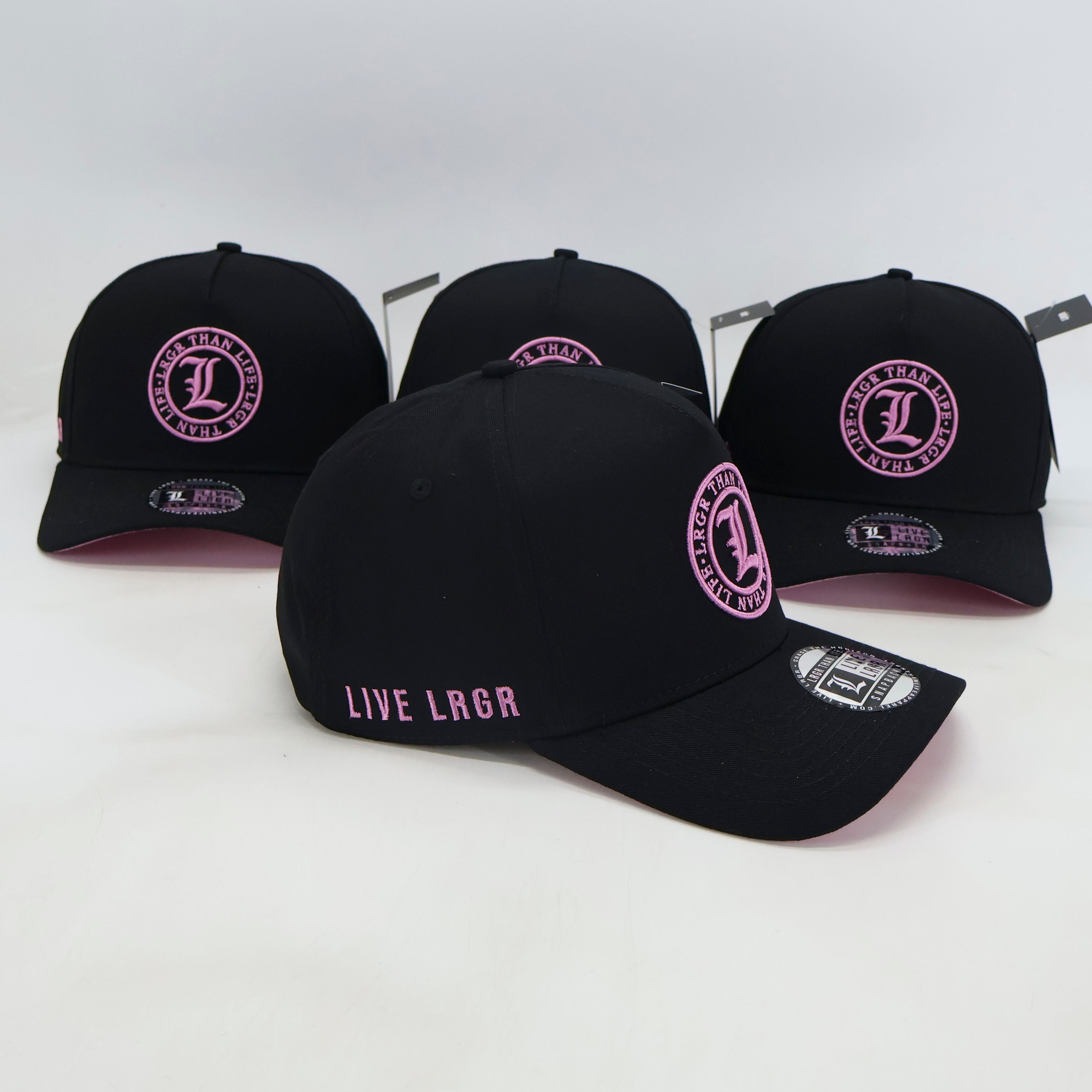 Black baseball caps with pink logo and text on a white background