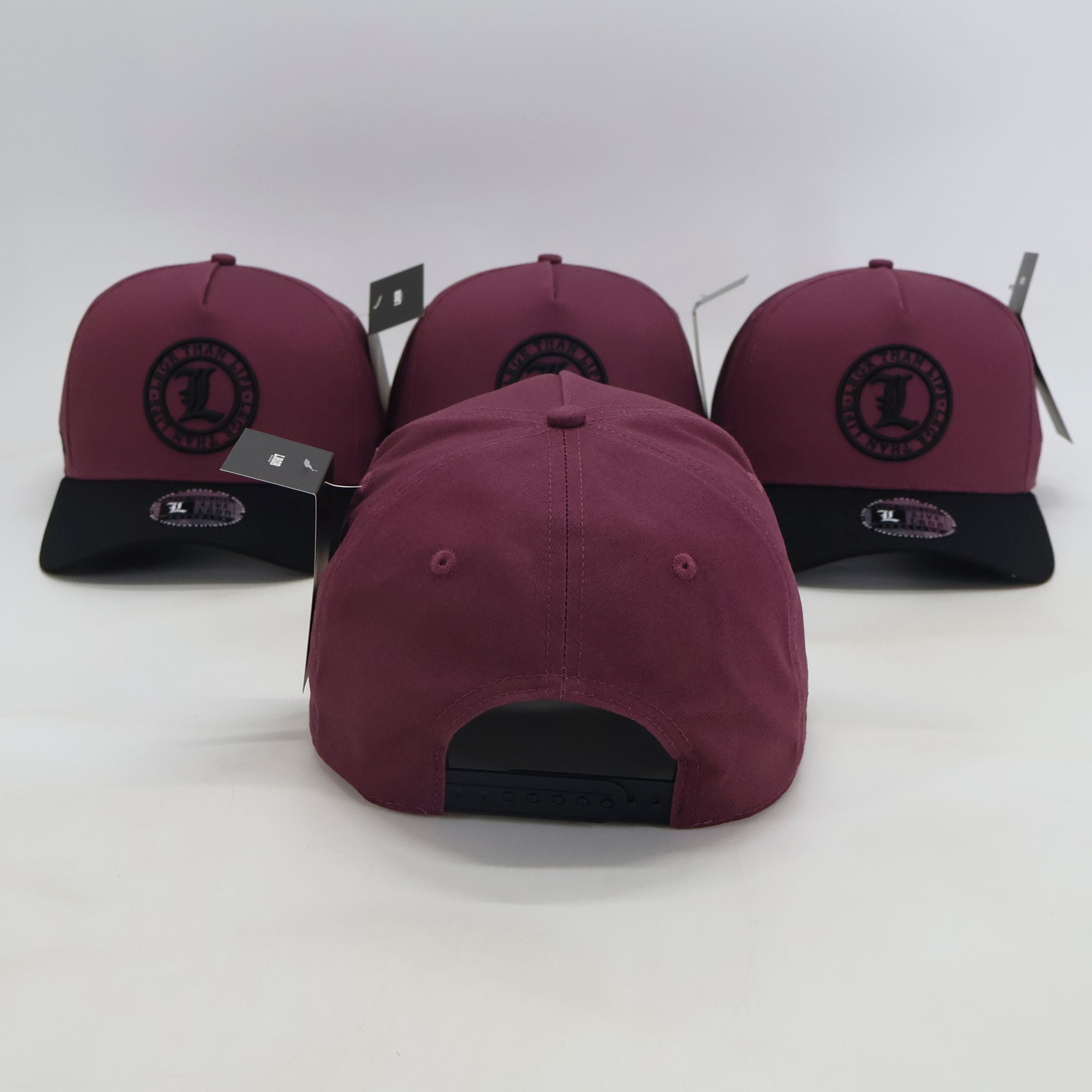 Purple and black baseball caps with brand logo on a white background