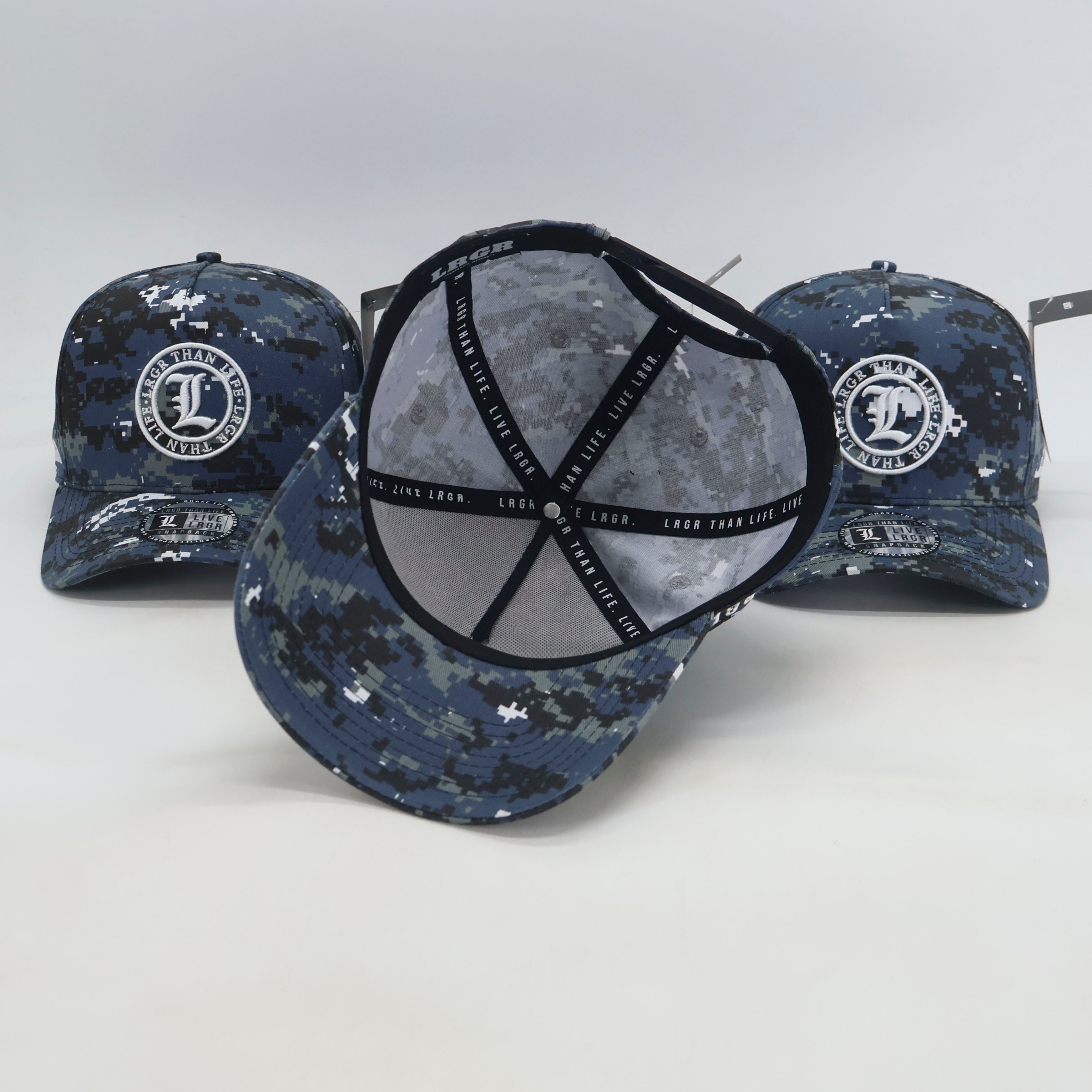 Three camouflage baseball caps with visible branding on a light gray background