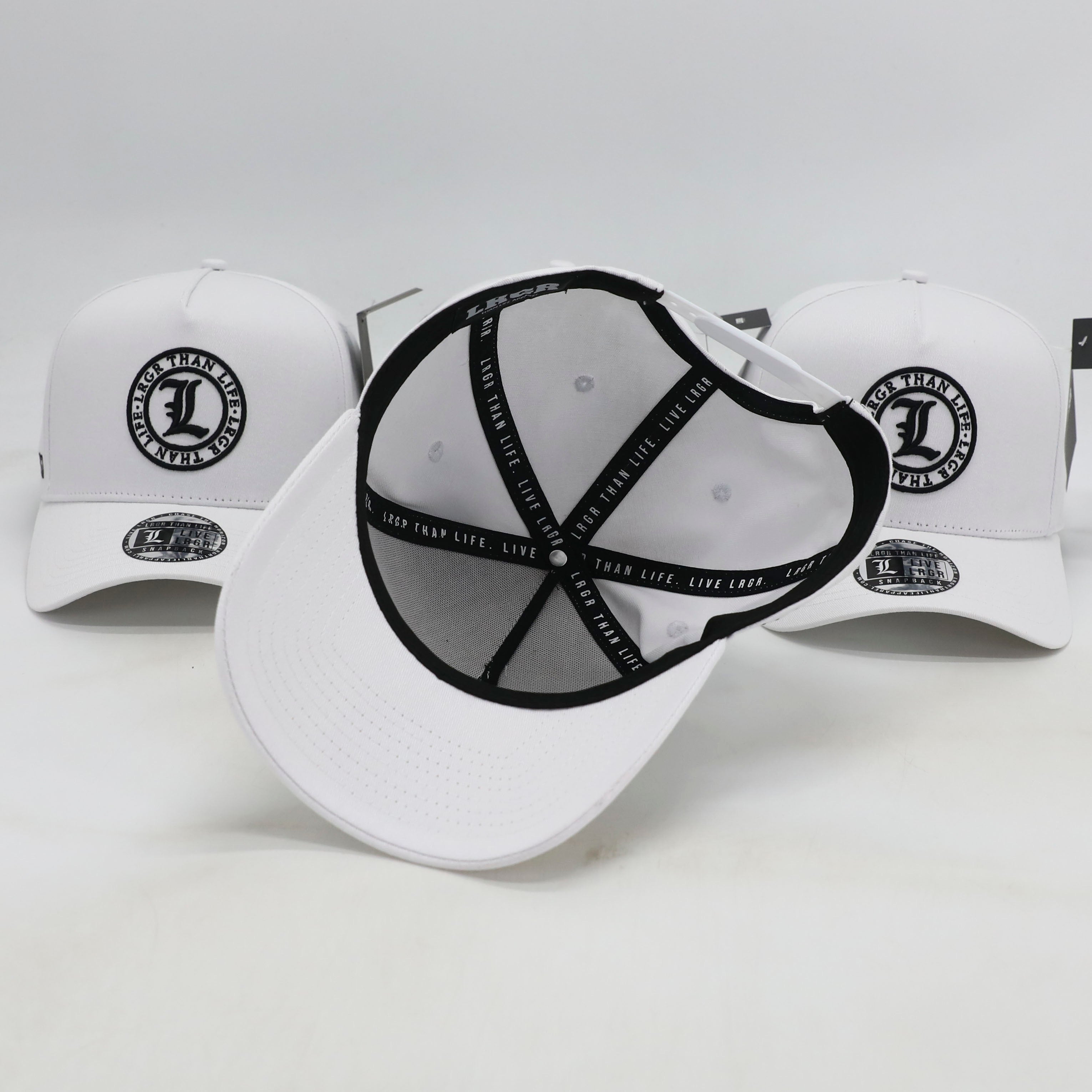 White baseball caps with black logos on a light gray background