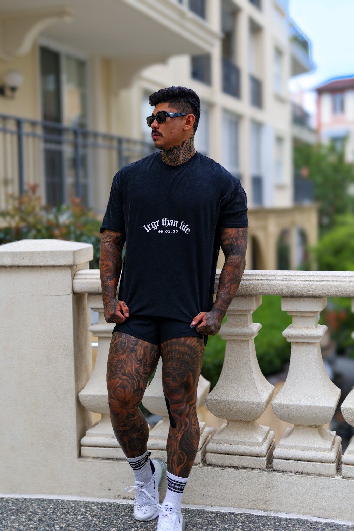 Man wearing a black t-shirt with 'EGO IS THE ANSWER' text, standing outdoors.