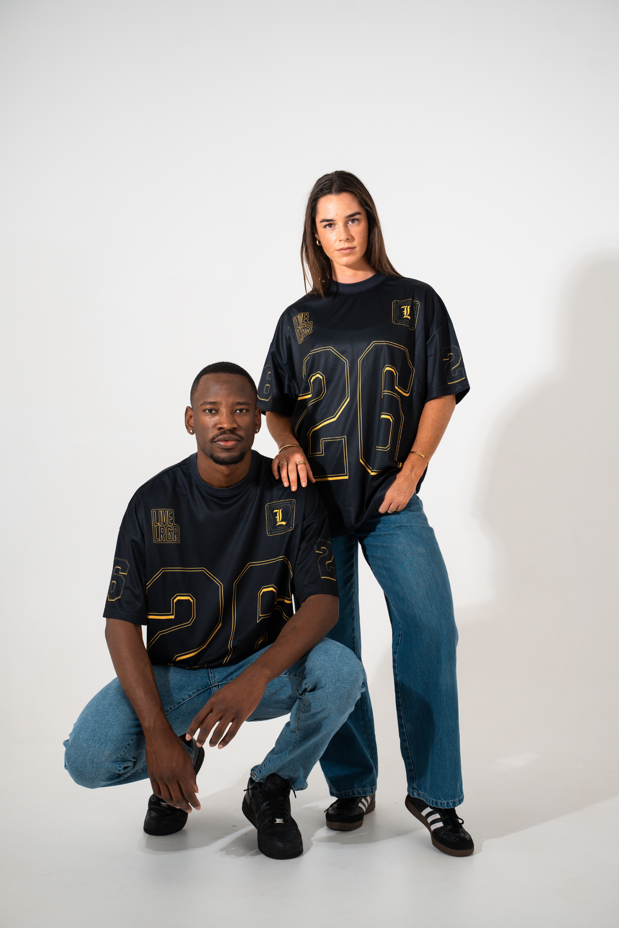 Two people wearing black jerseys with the number 26 on a white background