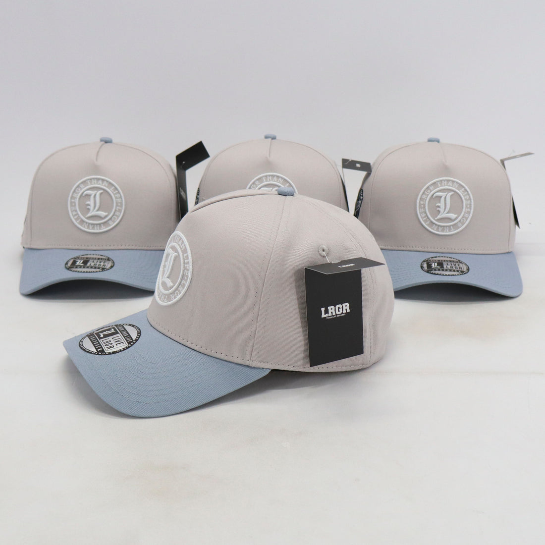 Gray and light blue baseball caps with branding on a white background
