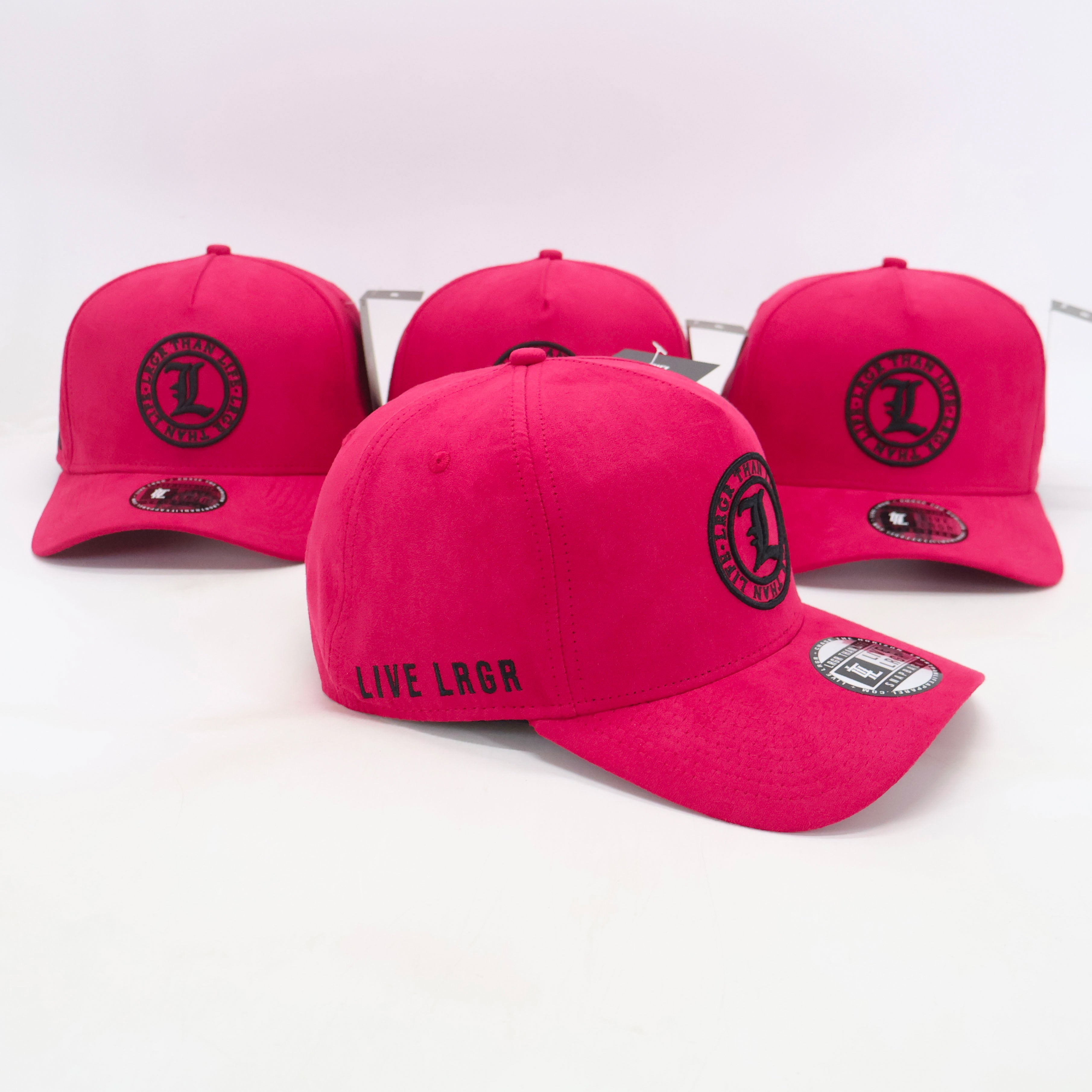 Four pink caps with black logos on a white background