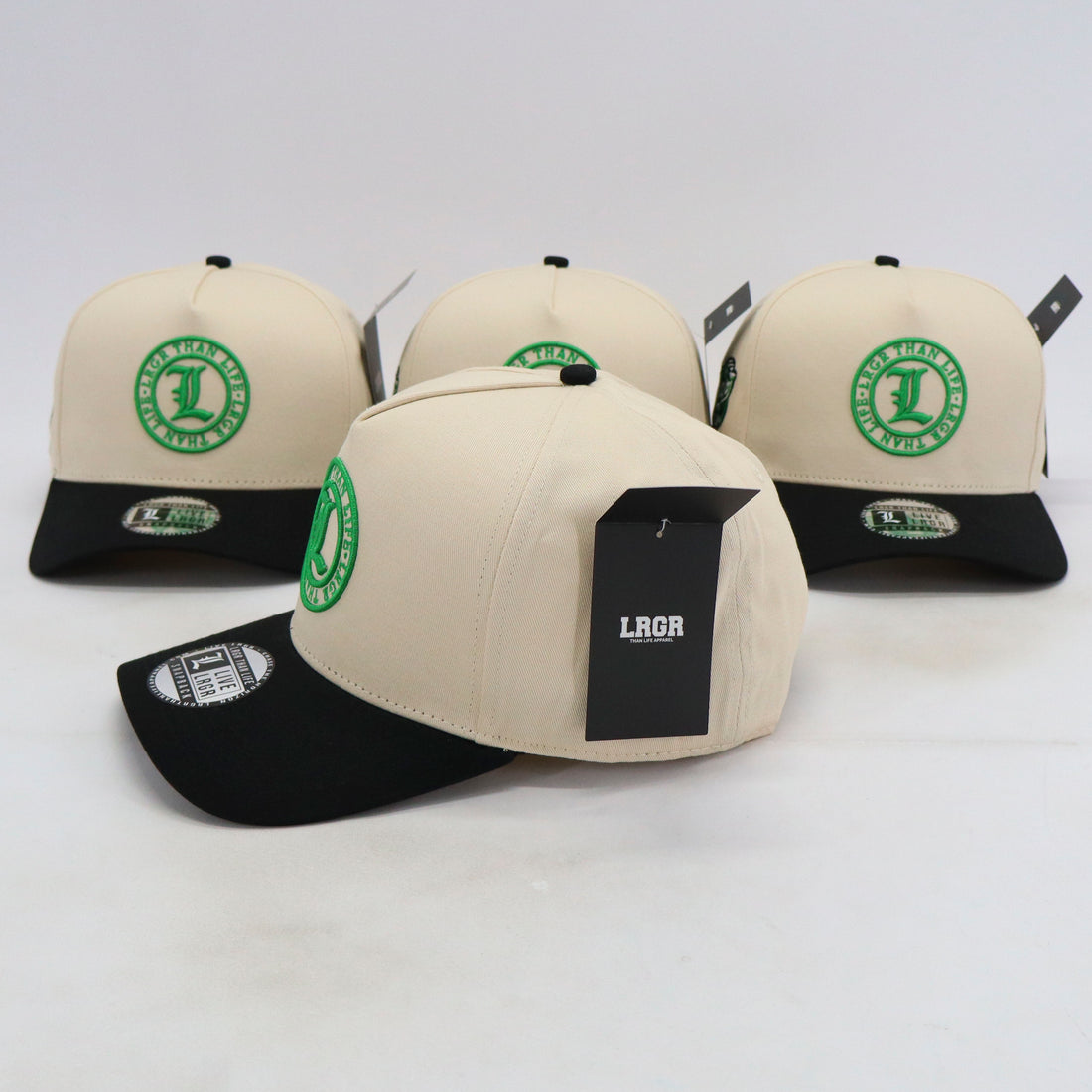 Four beige and black baseball caps with green logos on a white background