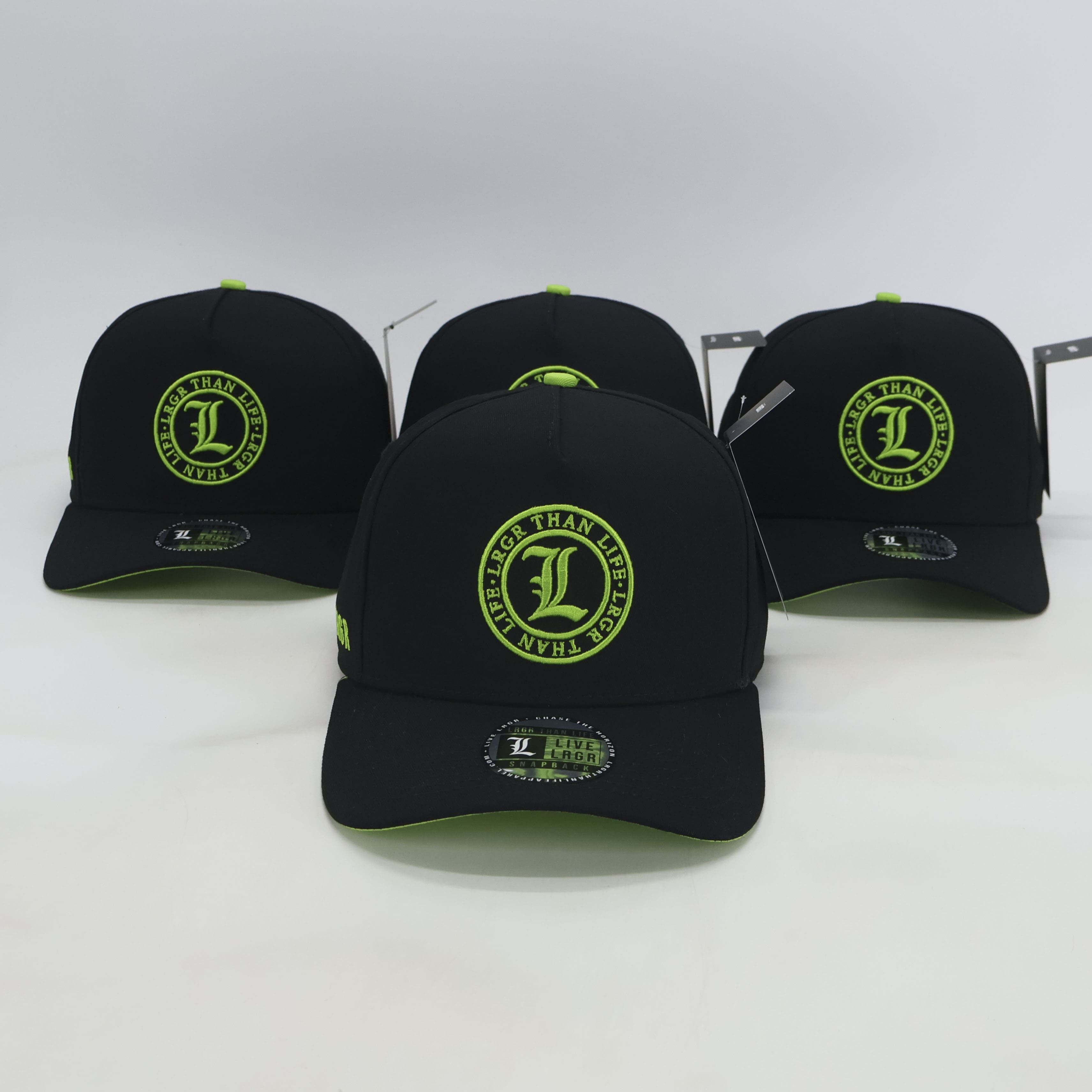 Three black caps with green logos on a white background