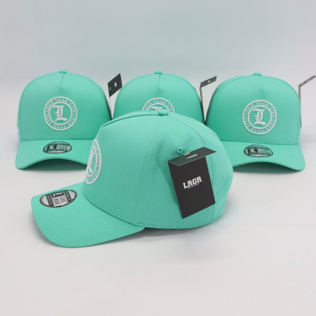 Four mint green caps with branding on a light gray background