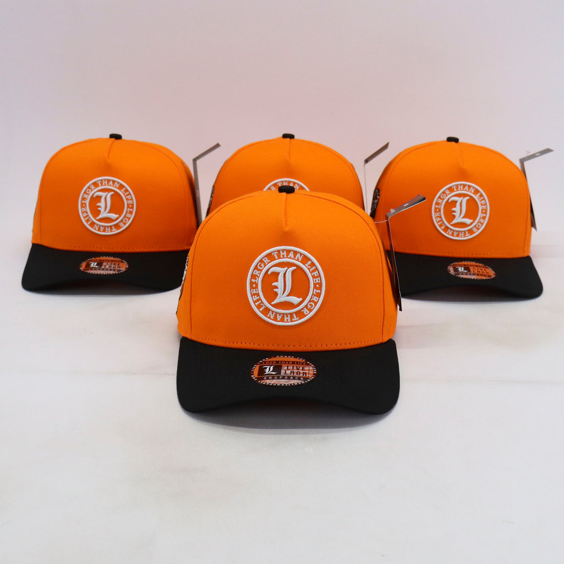 Four orange and black caps with a logo on a white background