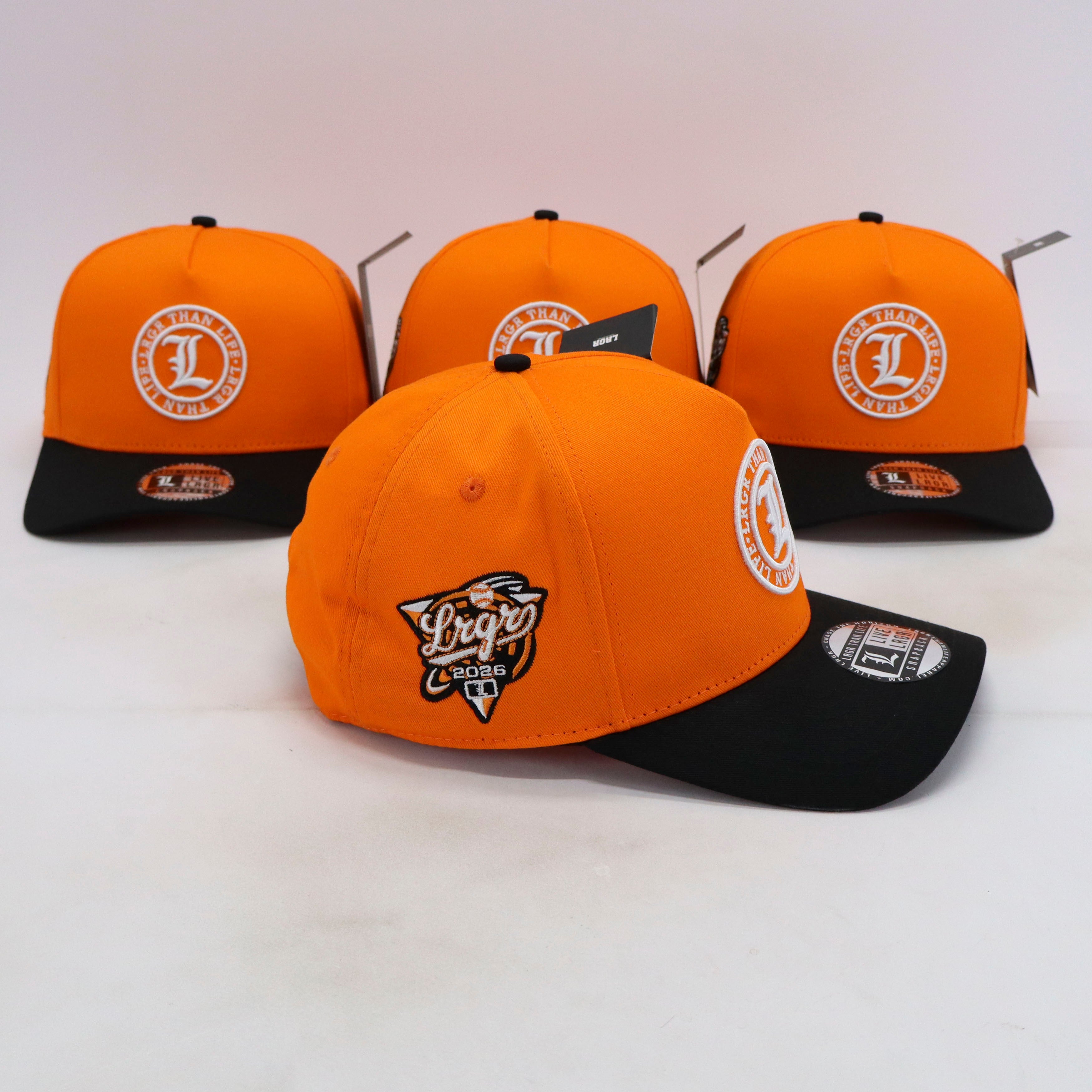 Four orange and black caps with logos on a white background