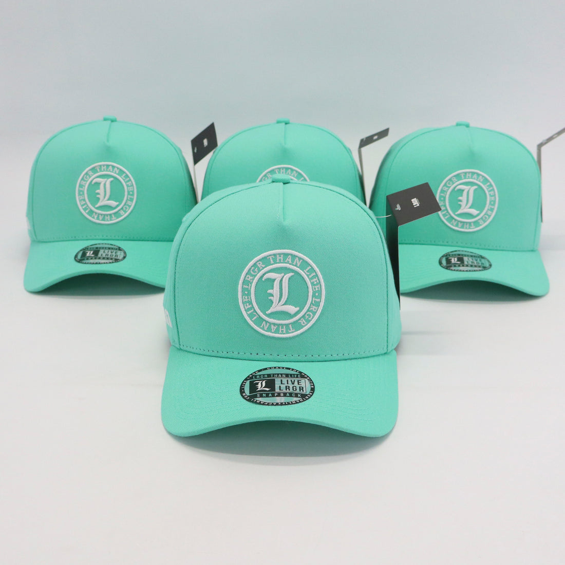 Three mint green caps with a logo on a light gray background