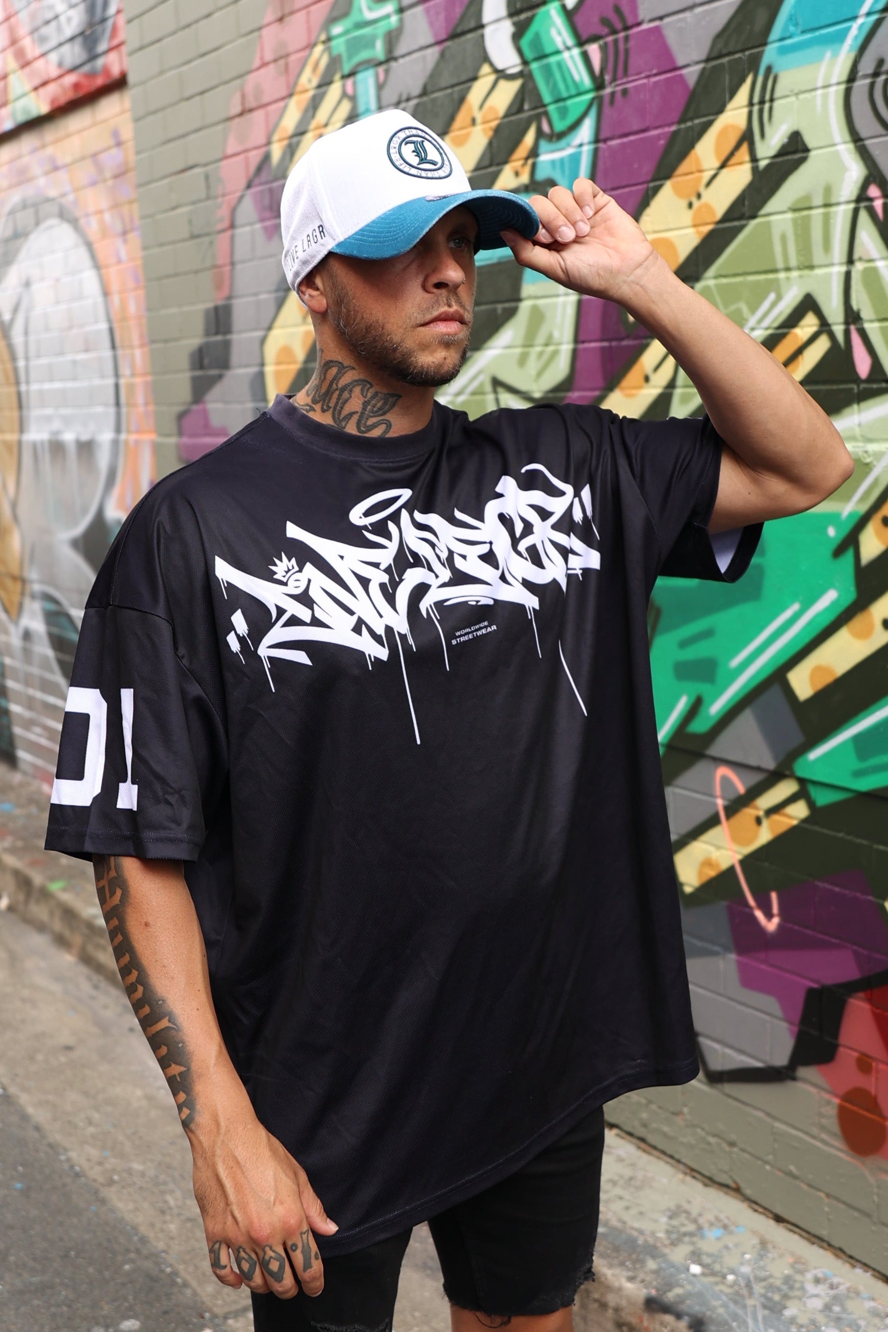 A people standing on a colorful street mural wearing a LRGR t-shirt