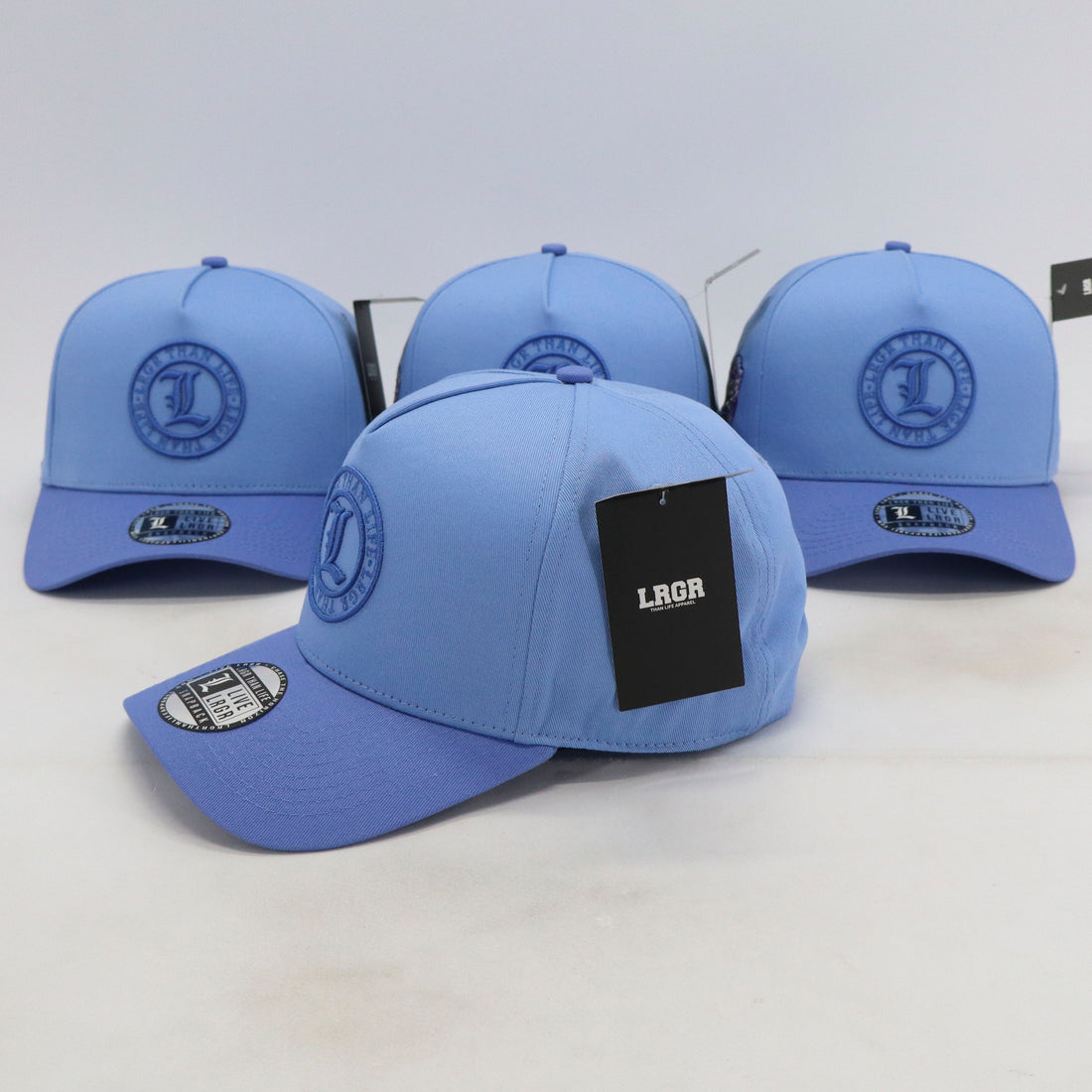 Four blue baseball caps with a logo on a white background