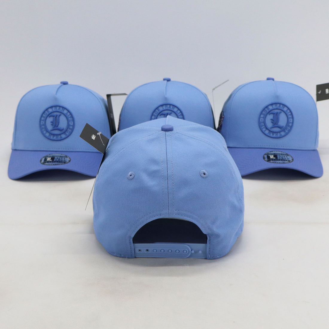 Three blue baseball caps with a logo on a white background