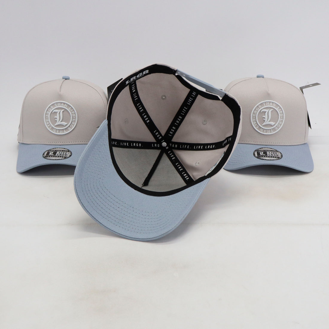 Three baseball caps with a logo on a light gray background
