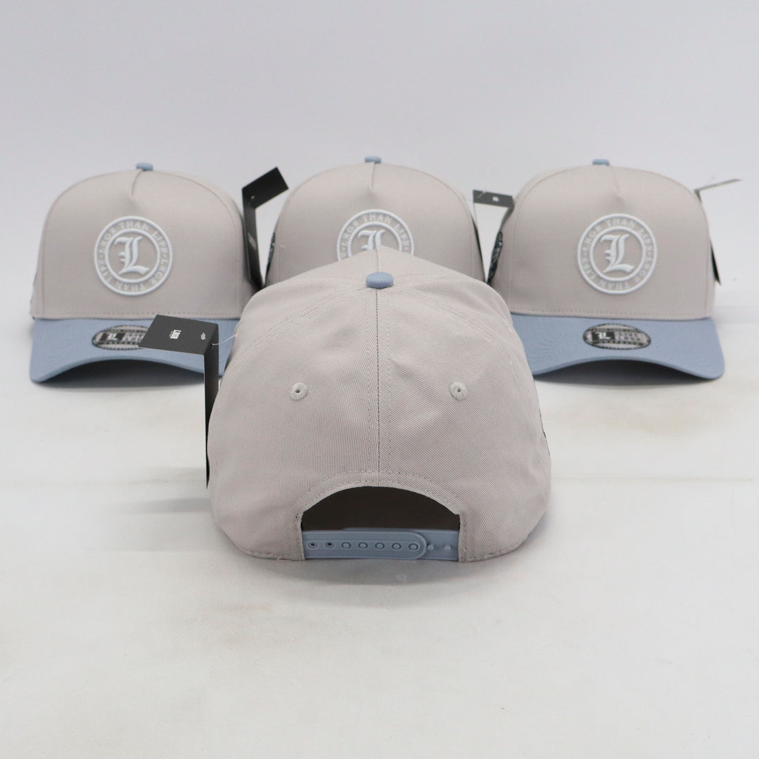 Three gray baseball caps with a logo on a white background