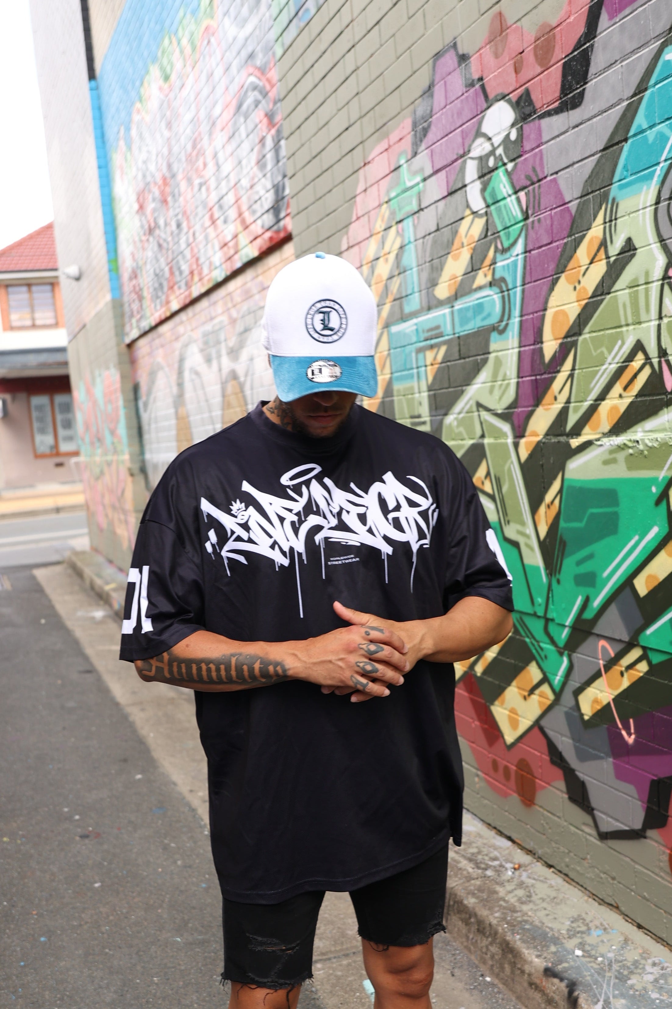 A people standing on a colorful street mural wearing a LRGR t-shirt