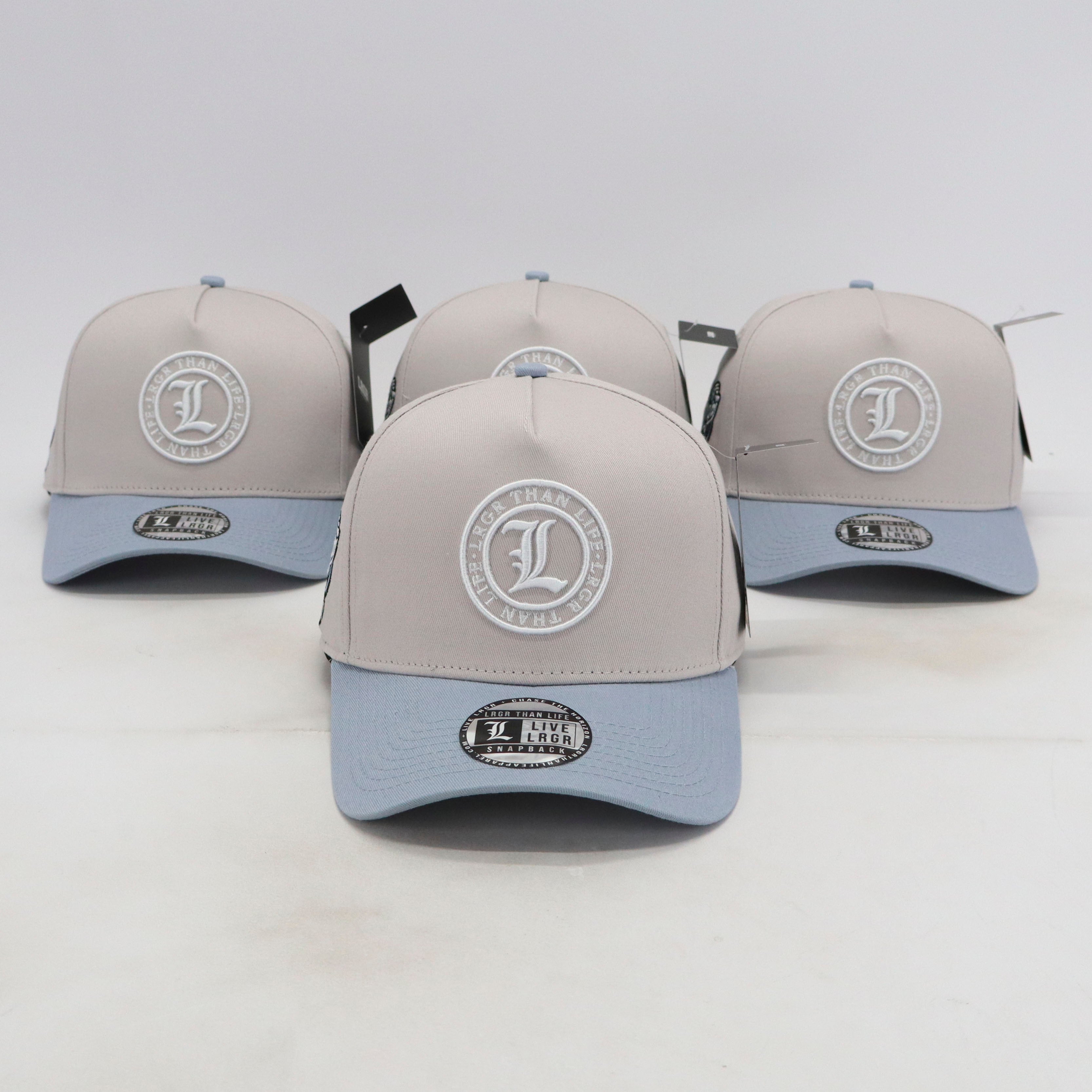 Four gray and light blue baseball caps with logos on a white background