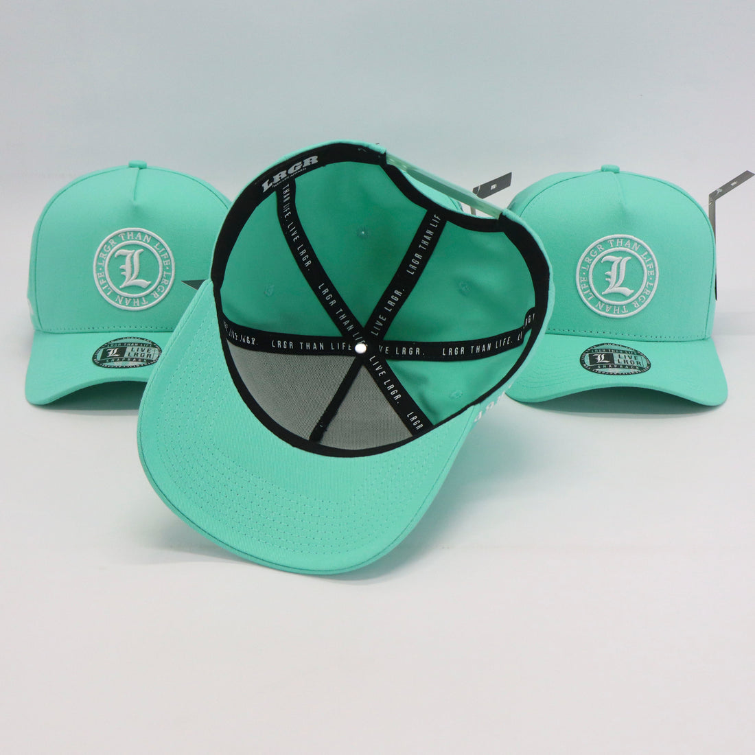 Three mint green caps with a central black band and visible brand logo on a light gray background.