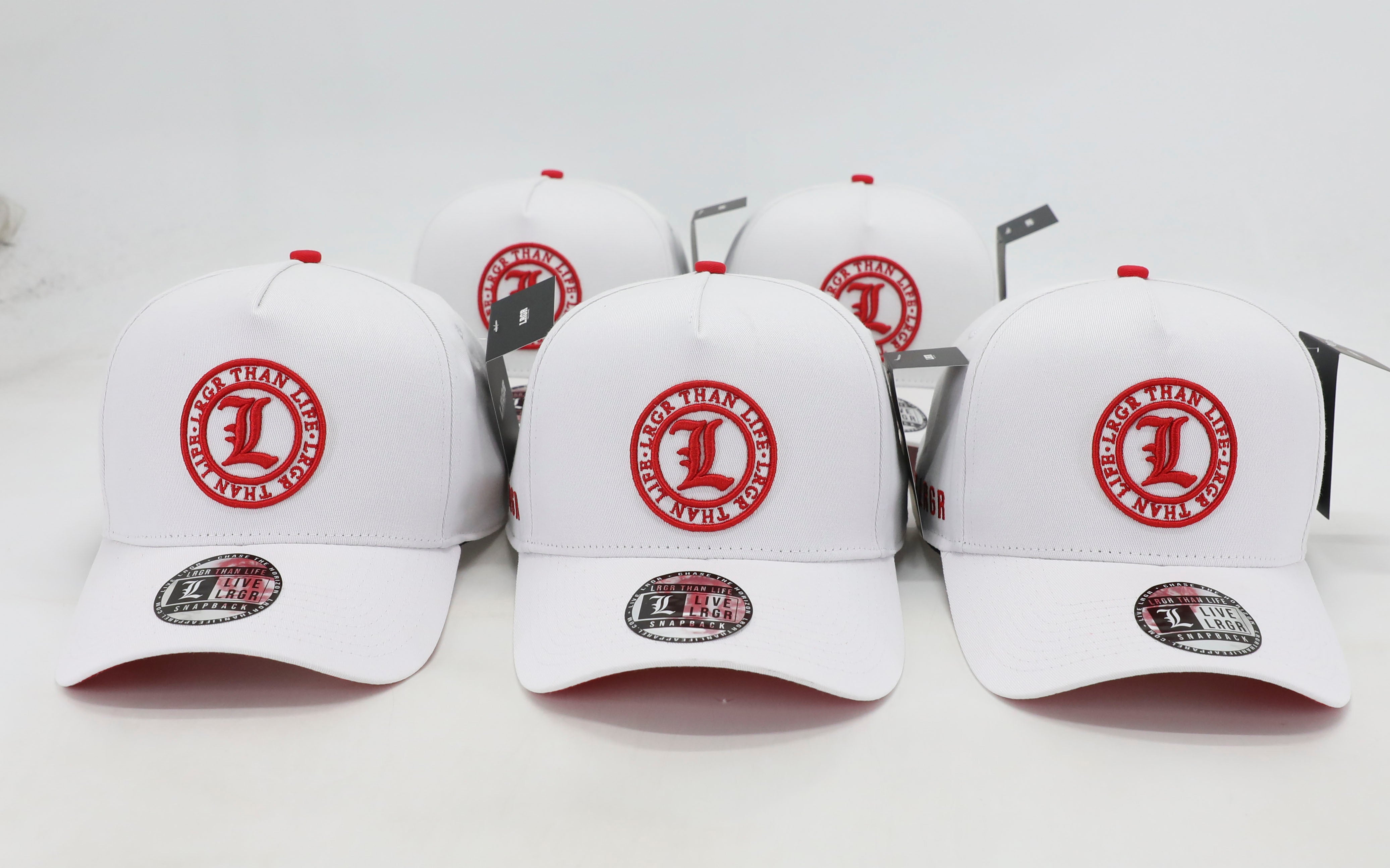 White baseball caps with red logos on a white background