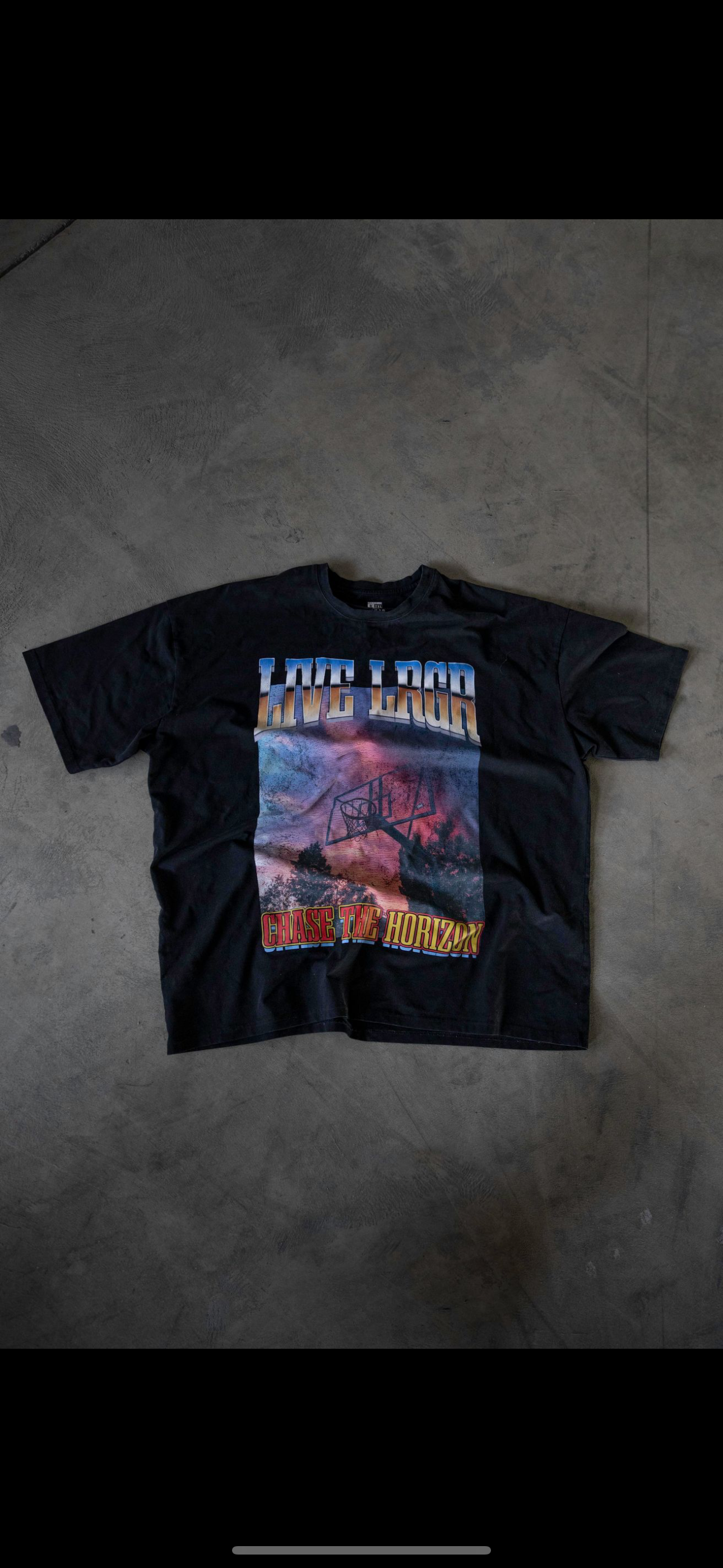 a LRGR graphic t-shirt and sunglasses, with a cityscape background.