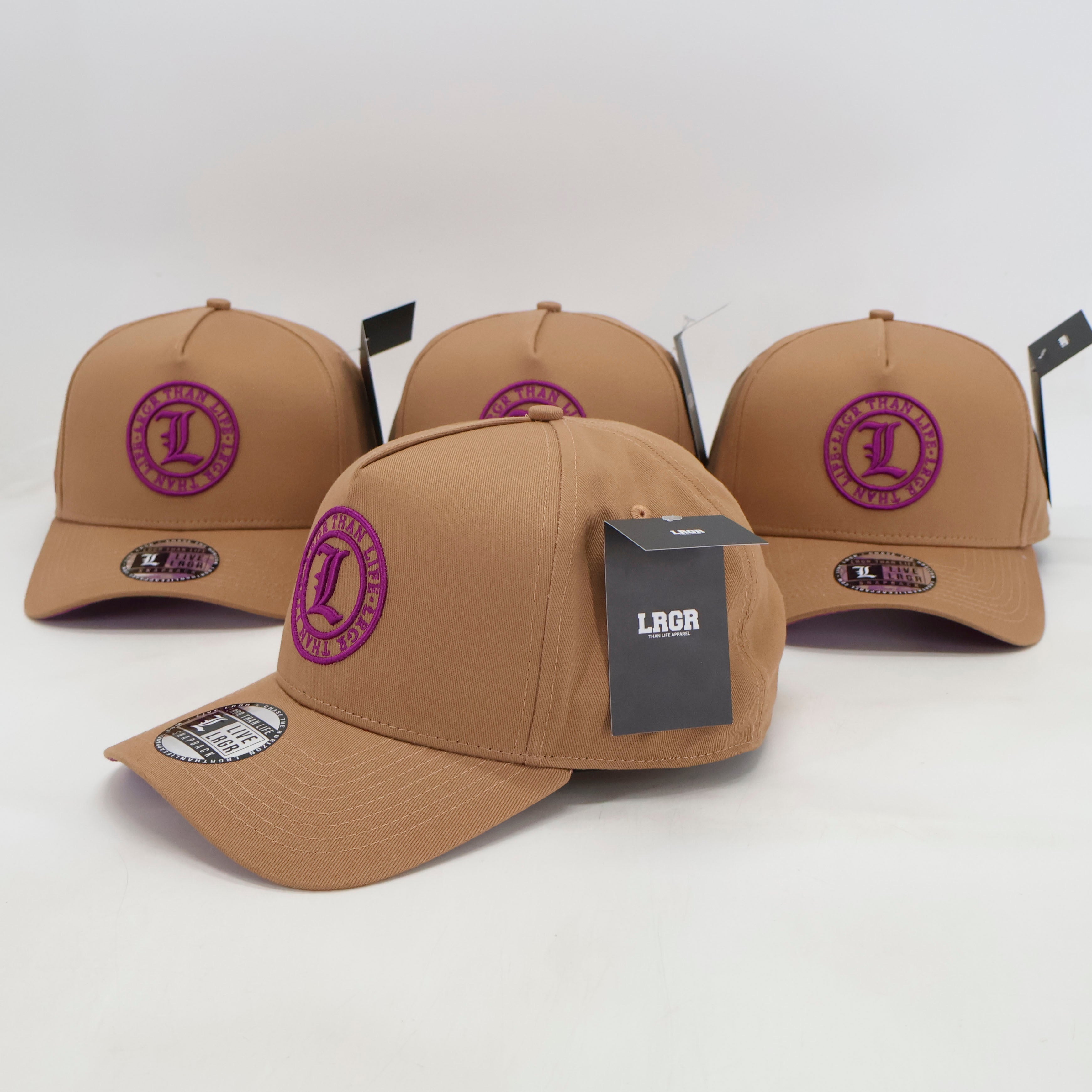 Four tan baseball caps with purple logos on a white background