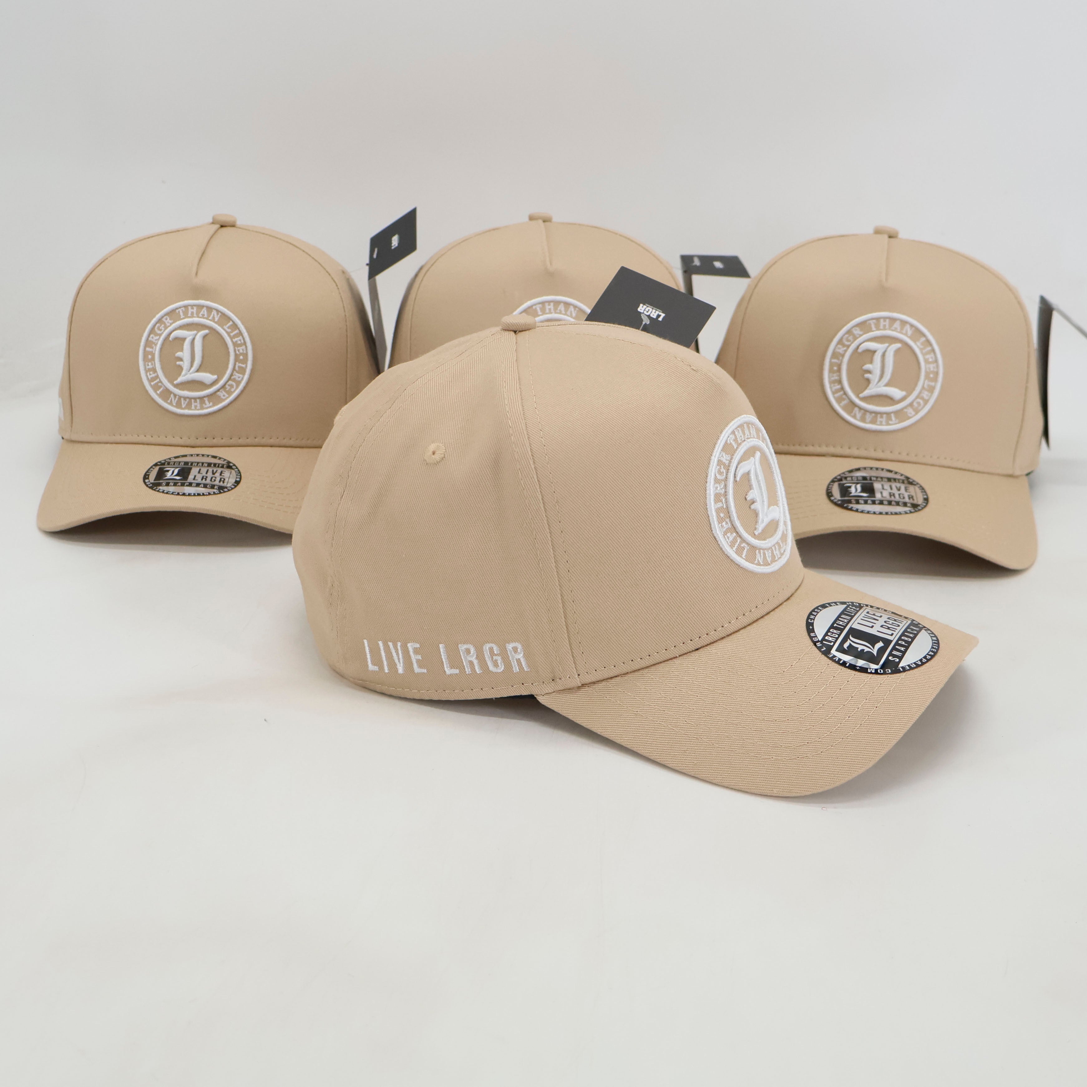 Three beige baseball caps with logos on a light gray background