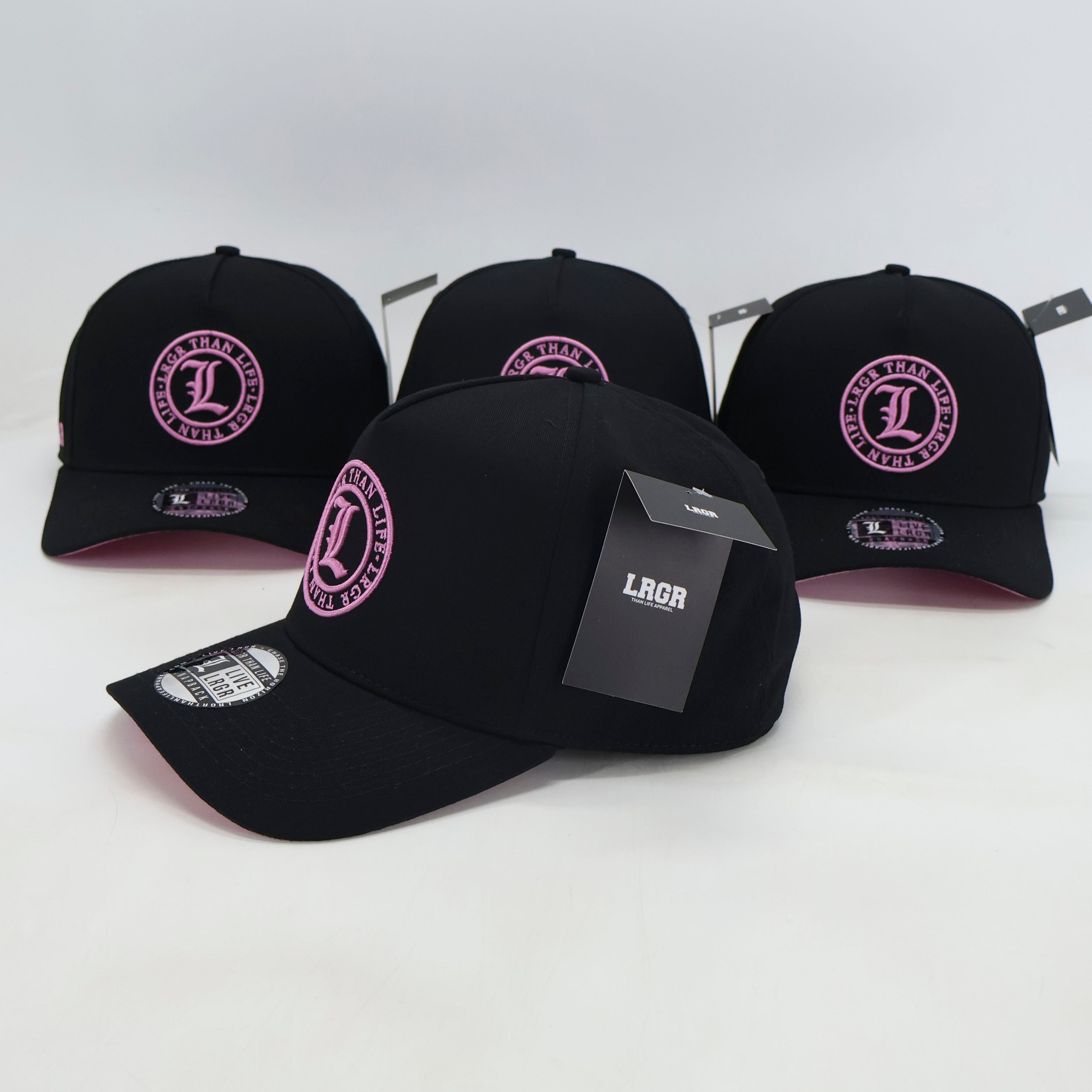 Black baseball caps with pink logos on a white background