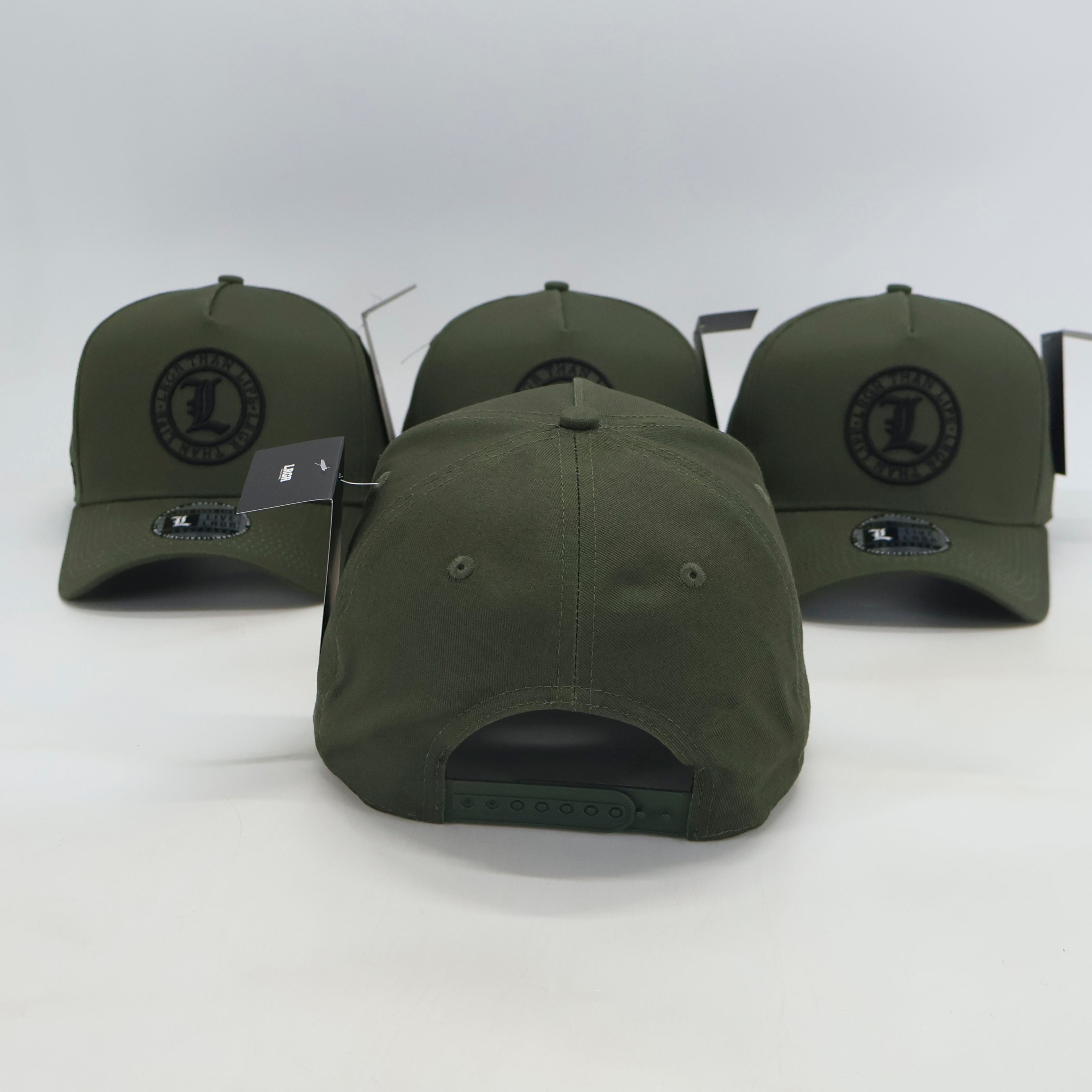 Four green baseball caps with a logo on a white background