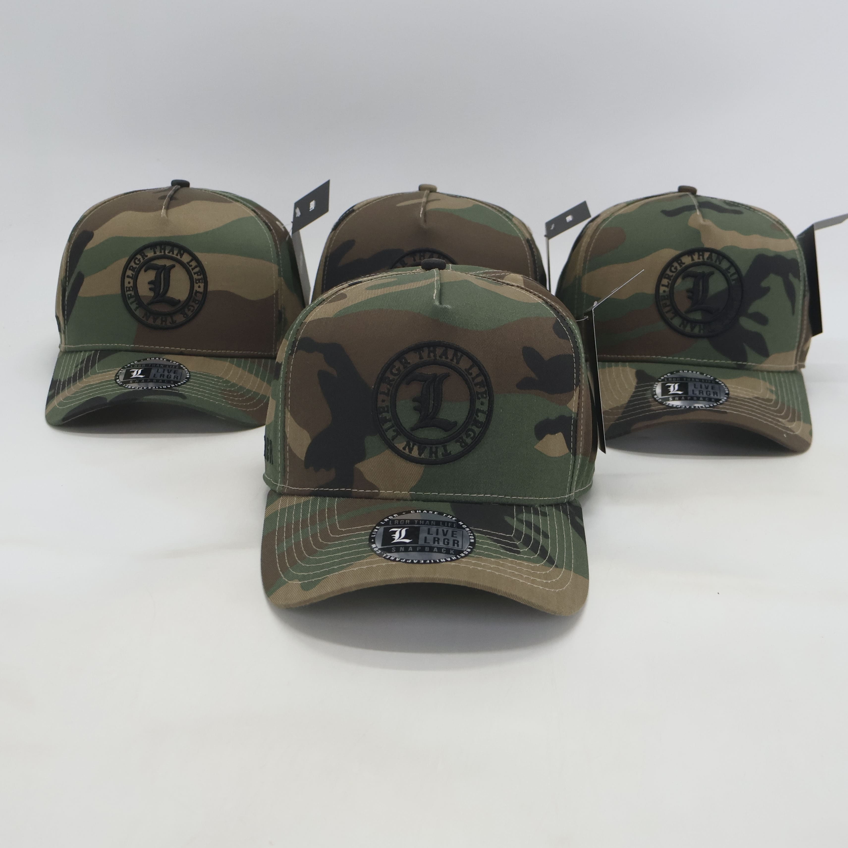 Four camouflage baseball caps with a logo on a white background